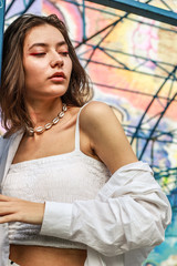 Fototapeta premium Young beautiful lady wearing a stylish white top.Portrait shooting of a stylish girl.Trends summer 2019.