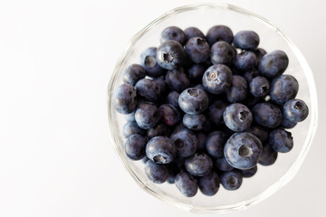 Blueberries in a bowl on white background.