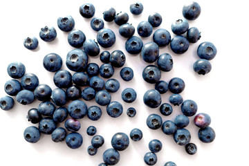 Blueberries scattered on a white table.