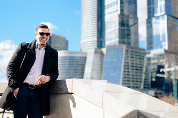 stylish young male businessman on the background of the cityscape