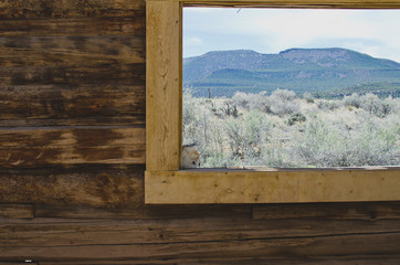 A view looking out the edge of the old log cabin window in utah.