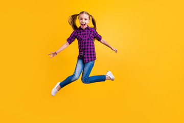 Fototapeta na wymiar Full size photo of small pupil jump high hooray celebrate holidays wear casual checkered shirt jeans denim isolated yellow background