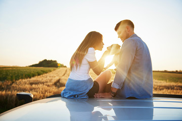 Young couple playing with dog outdoors
