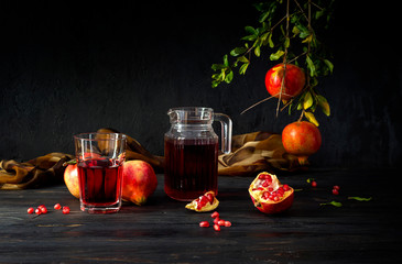 Pomegranates and pomegranate juice on a dark background