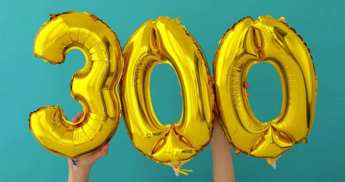 Gold foil number 300 three hundred celebration balloon on a blue background