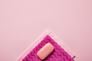 top view of pink rags and soap on pink background