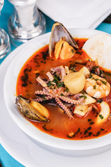 Tomato soup made from chicken, rings of colmar, octopus, mussels and vegetables according to a Mediterranean recipe