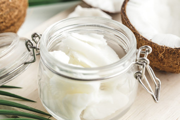 Organic healthy coconut butter and fresh coconut pieces on wooden board