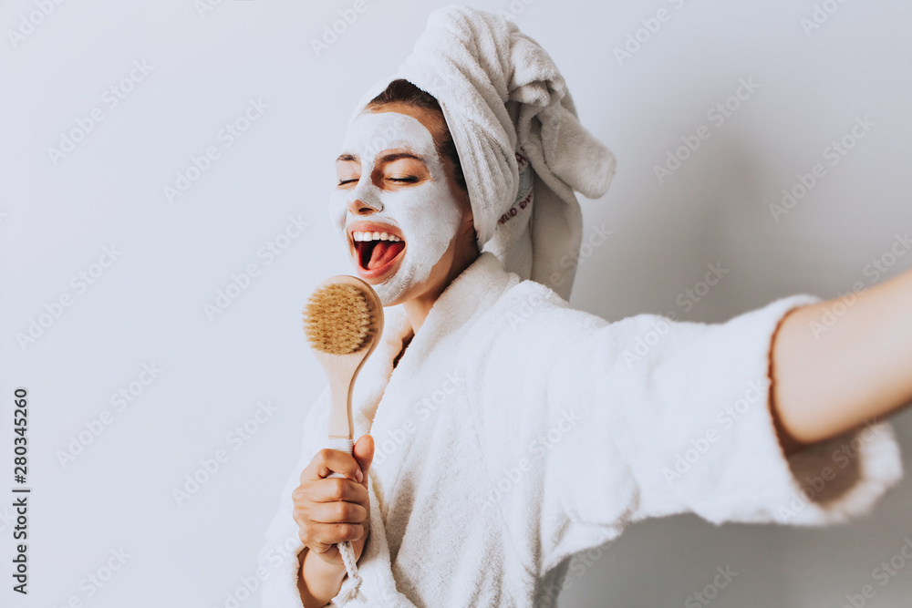 Wall mural attractive young woman sitting with a facial mask on her skin.beauty procedures skin care concept.