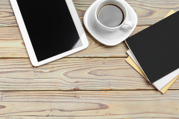Work space. Digital tablet and coffee cup with supplies, still life