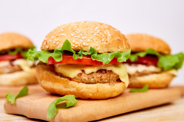 Craft beef burger  on wooden table on light background. Street food, fast food. Homemade juicy burgers with cheese and  on the wooden table. Copy space.