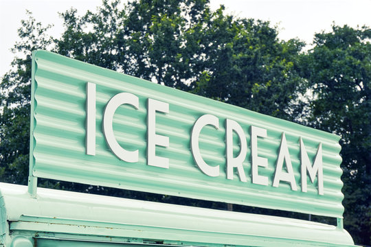 Ice cream sign. Retro image of roof of a light green food truck with white text ice cream. To be used as a retro summer background.