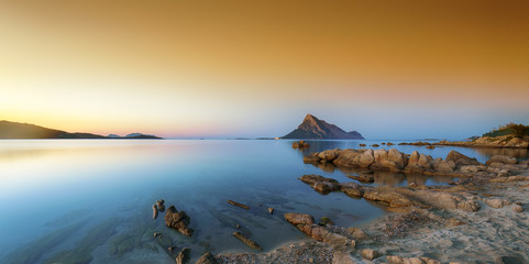 Fantastic azure water with rocks near beach Porto Taverna at sunset