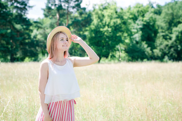 Obraz premium Young beautiful girl with pink hair in the summer hat