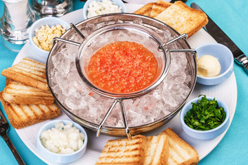 Mediterranean red caviar appetizer on ice, toast, butter, and a set of sauces