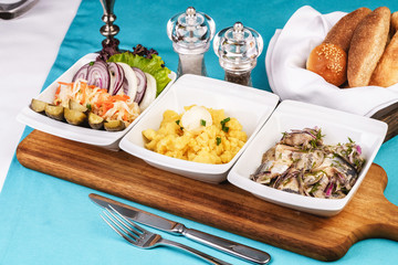 Mediterranean snack of puree, pickled herring, quail eggs, pickled cucumbers, onion rings, pickled cabbage, onions and greens