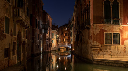 Obraz na płótnie Canvas Small canal in Venice by night with a beautiful old bridge