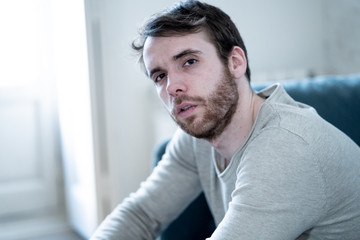 Young man suffering from depression hopeless and alone at home