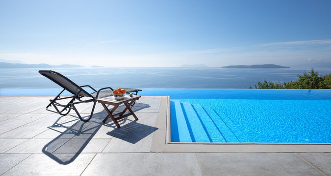Beautiful view of the sea. In the foreground an infinity pool with a lounger 