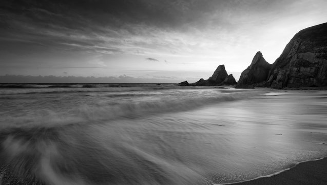 Stunning black adn white sunset landscape image of Westcombe Beach in Devon England