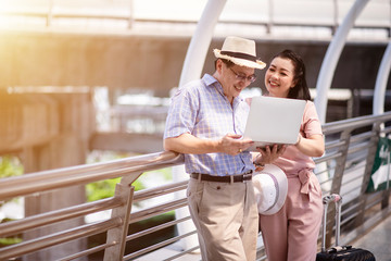 Elderly couple using a laptop to find information while they are traveling abroad.