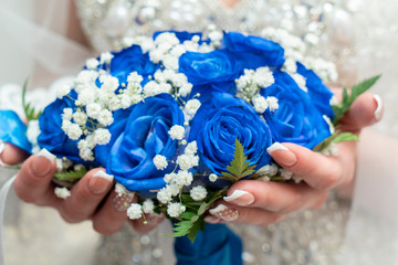 wedding background,wedding bouquet of blue flowers in the hands of the bride close-up