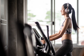Fototapeta na wymiar Young woman cardio in the gym while listening music