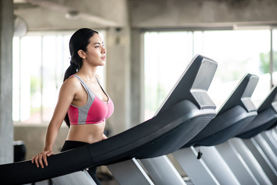 Young healthy woman cardio on trendmill in the gym