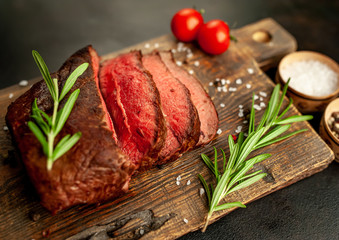 Fresh beef steak, herbs and spices on a stone background