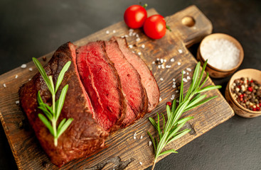 Fresh beef steak, herbs and spices on a stone background