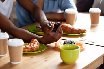 Close up black young man hands holding smartphone.