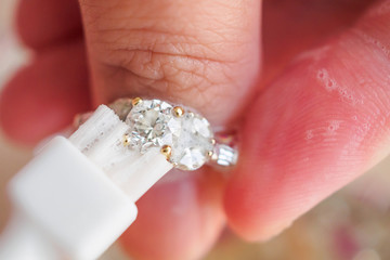 Jeweller hand cleaning and polishing vintage jewelry diamond ring closeup macro
