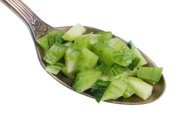 In the old golden spoon there is a small pieces  of food - green chopped marrow squash zucchini isolated macro