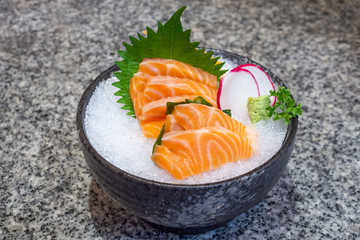 salmon sashimi on ice in black bowl japanese food