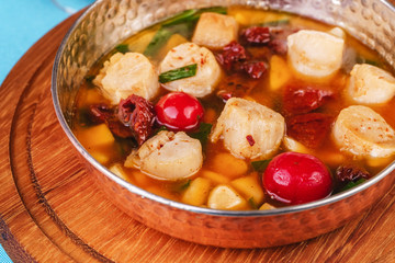 Italian fish soup with tomatoes, dough, dumplings, potatoes and greens. Mediterranean cuisine, European dish