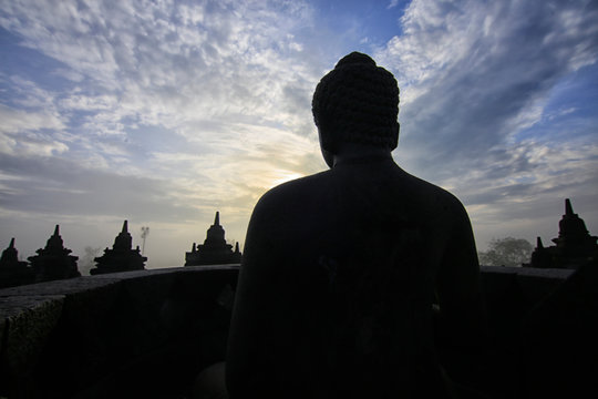 Silhouette of a Buddha statue at sunrise, Borobudur Temple, Magelang, Central Java, Indonesia