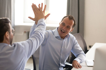 Happy male employee giving high five to colleague