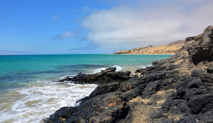 Fototapeta na wymiar Empty Rocky Beach with Turquoise Water in Fuerteventura, Canary Islands