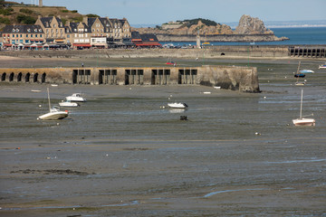 Boats on dry land at the beach at low tide in Cancale famous oysters production town, Brittany,...