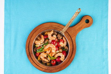 Seafood, Mediterranean cuisine, European dish. Warm salad of grilled fish pieces, shrimps and mussels in a frying pan, with grilled vegetables - with green onions, greens, mushrooms and vegetables.