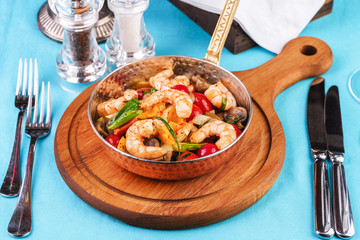 Seafood, Mediterranean cuisine, European dish. Warm salad of grilled fish pieces, shrimps and mussels in a frying pan, with grilled vegetables - with green onions, greens, mushrooms and vegetables.