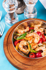 Seafood, Mediterranean cuisine, European dish. Warm salad of grilled fish pieces, shrimps and mussels in a frying pan, with grilled vegetables - with green onions, greens, mushrooms and vegetables.