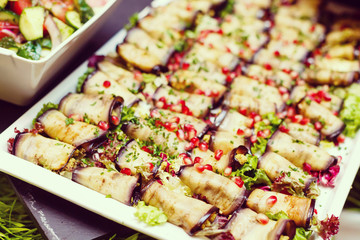 Eggplant rolls with walnuts. Delicious fried aubergines with nuts, herbs and pomegranate seeds. Dish of Georgian cuisine.