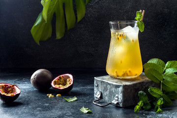 Passionfruit iced green tea or lemonade with lime and mint. Tropical refreshing cold drink for...