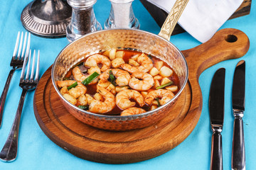 Seafood, Mediterranean cuisine, European dish. Warm salad of grilled fish pieces, shrimps and mussels in a frying pan, with grilled vegetables - with green onions, greens, mushrooms and vegetables.