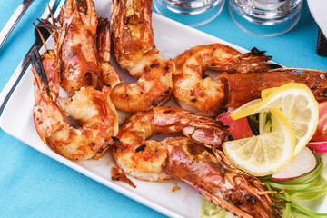 European cuisine, Mediterranean dish. Plate with assorted sea grill for beer. Fried king prawns with lemon, mussels with oyster sauce, Colmar rings, crab meat