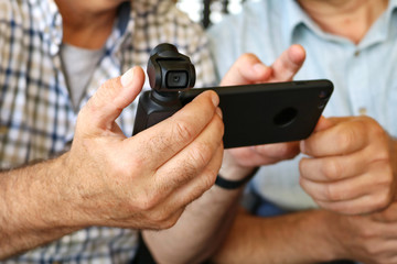 Men's hands set up a new camera and mobile phone