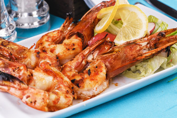 European cuisine, Mediterranean dish. Plate with assorted sea grill for beer. Fried king prawns with lemon, mussels with oyster sauce, Colmar rings, crab meat