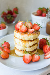 Cottage cheese pancakes syrniki with strawberries and honey. The concept of tasty healthy summer Breakfast. Copy space, side view.