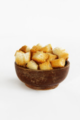 fried dry white bread crackers in a wooden plate on a white background